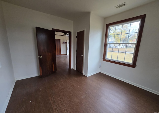 spare room with dark hardwood / wood-style flooring and ceiling fan