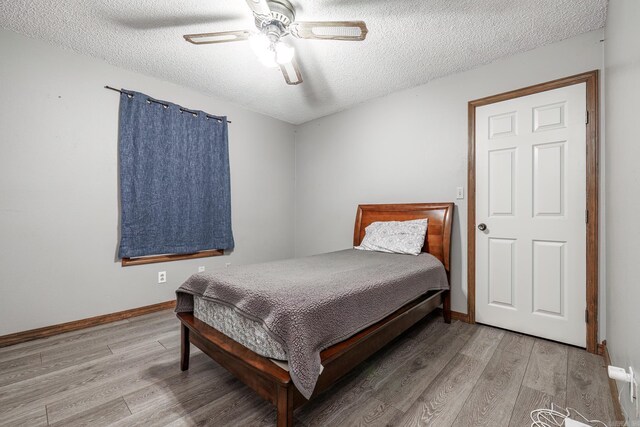 bedroom featuring hardwood / wood-style floors, a textured ceiling, and ceiling fan