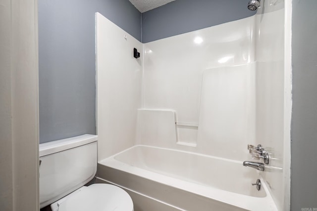 bathroom with shower / bathing tub combination, toilet, and a textured ceiling