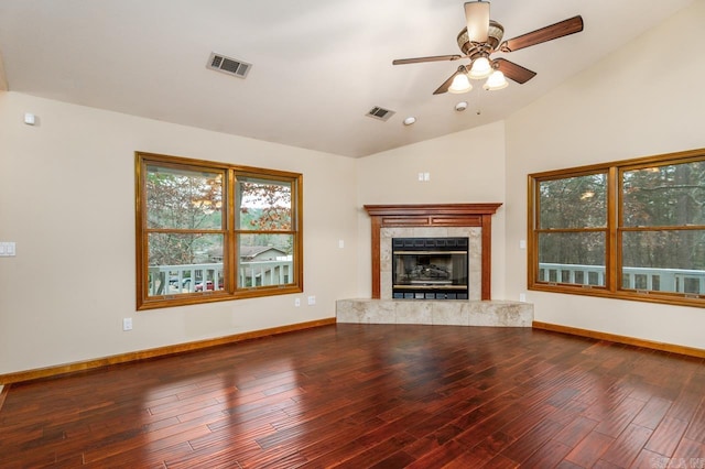 unfurnished living room featuring a tiled fireplace, ceiling fan, hardwood / wood-style floors, and lofted ceiling