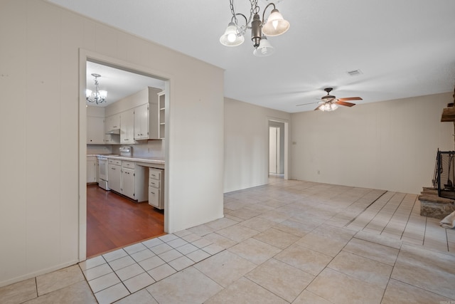 unfurnished living room with light tile patterned floors and ceiling fan with notable chandelier