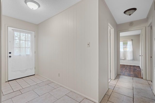 interior space featuring a healthy amount of sunlight, light tile patterned floors, and a textured ceiling