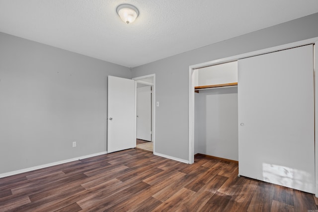 unfurnished bedroom with a textured ceiling, a closet, and dark hardwood / wood-style floors