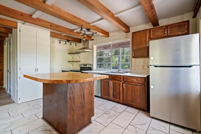 kitchen with sink, beamed ceiling, a kitchen island, exhaust hood, and appliances with stainless steel finishes