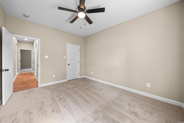 unfurnished bedroom featuring ceiling fan and light colored carpet