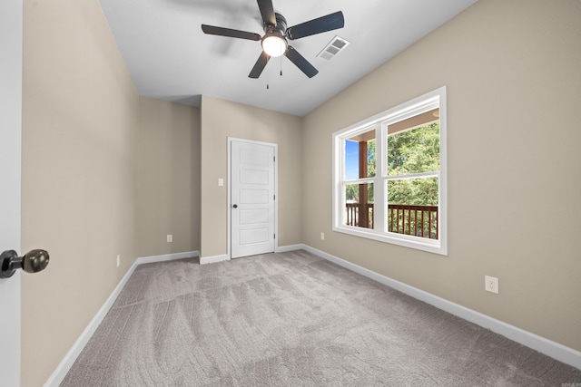 carpeted spare room featuring ceiling fan