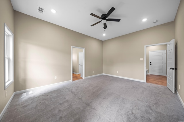 carpeted spare room with ceiling fan