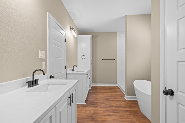 bathroom featuring a bath, vanity, and wood-type flooring