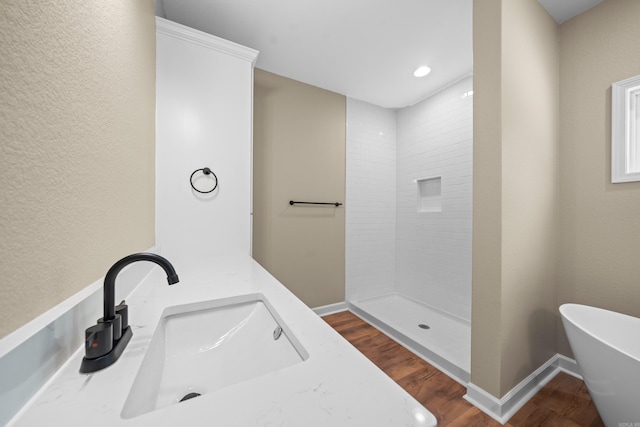 bathroom with hardwood / wood-style floors, vanity, and independent shower and bath