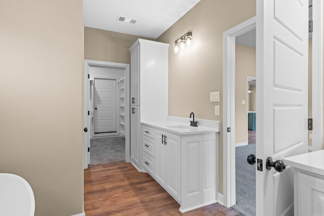 bathroom featuring a tub, hardwood / wood-style floors, and vanity