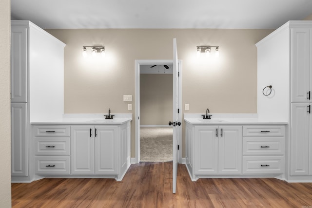 bathroom featuring ceiling fan, hardwood / wood-style floors, and vanity