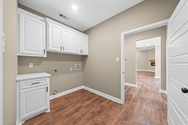 laundry area featuring hookup for an electric dryer, hookup for a washing machine, cabinets, gas dryer hookup, and hardwood / wood-style flooring