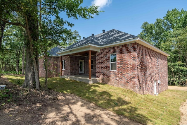 back of house with a yard and a patio