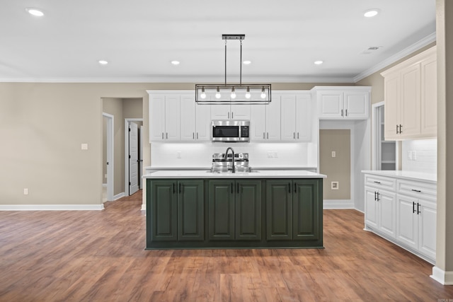 kitchen featuring appliances with stainless steel finishes, light hardwood / wood-style flooring, and a kitchen island with sink