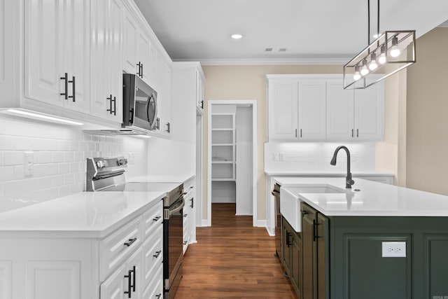 kitchen with white cabinets, pendant lighting, and stainless steel appliances