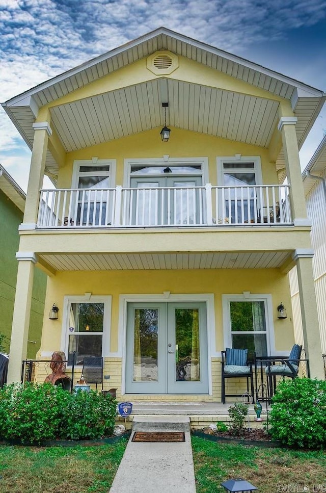 back of house with french doors and a balcony