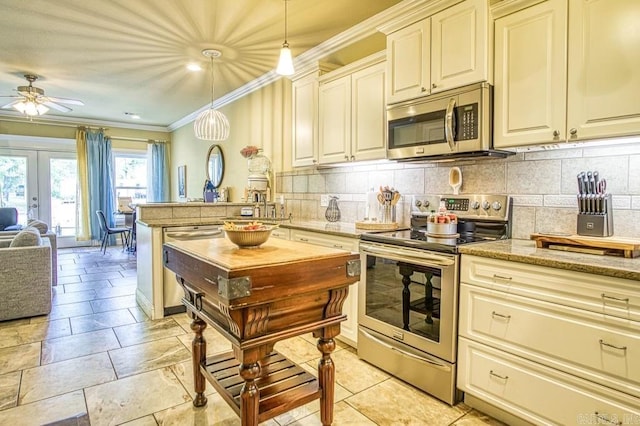 kitchen featuring french doors, tasteful backsplash, stainless steel appliances, ceiling fan, and hanging light fixtures