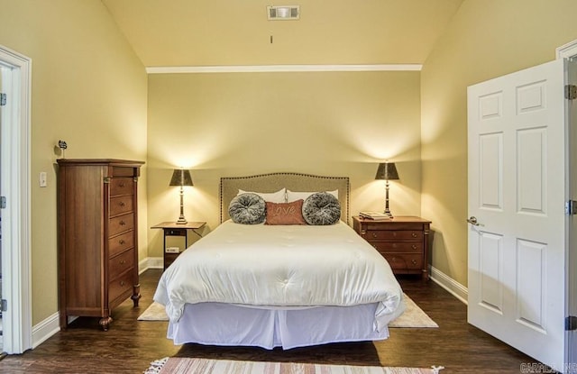 bedroom featuring dark hardwood / wood-style flooring, crown molding, and vaulted ceiling