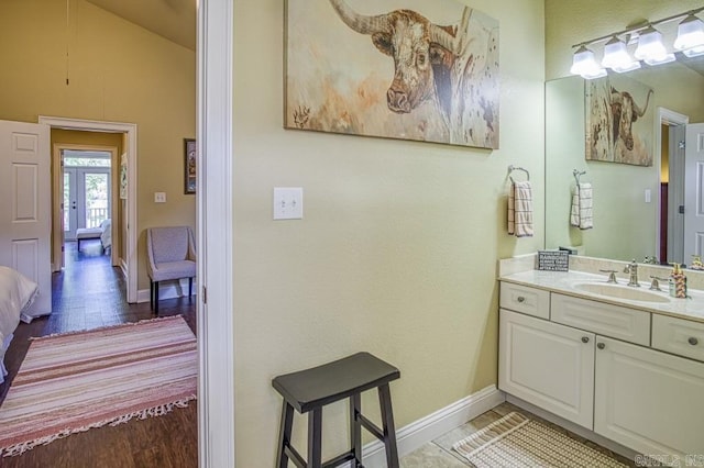 bathroom featuring hardwood / wood-style floors, vanity, and vaulted ceiling