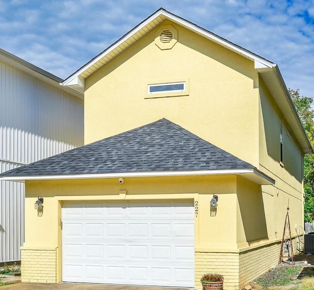 view of side of property with cooling unit and a garage