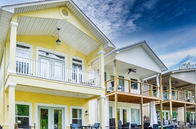 rear view of property featuring a balcony and ceiling fan