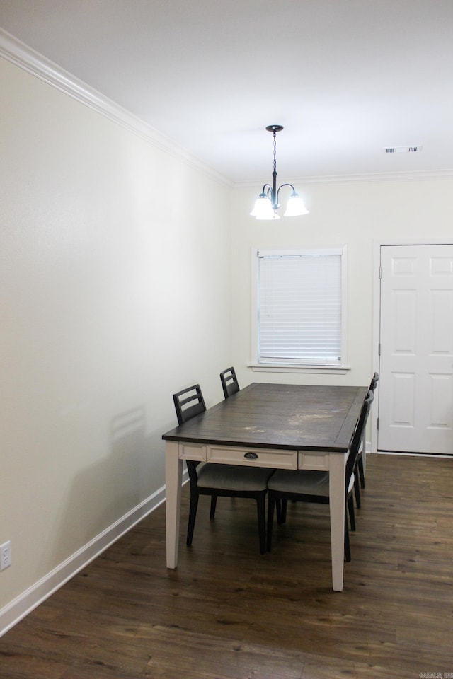 dining area featuring dark hardwood / wood-style floors, ornamental molding, and a notable chandelier