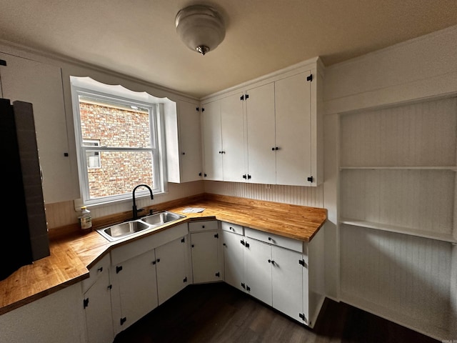 kitchen featuring white cabinetry, sink, wooden counters, and dark hardwood / wood-style floors