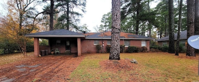 back of house with a carport and a lawn