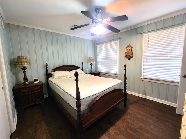 bedroom featuring ceiling fan, ornamental molding, dark wood-type flooring, and multiple windows