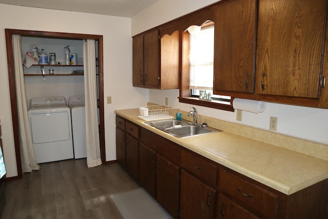 kitchen featuring washer and clothes dryer, dark hardwood / wood-style flooring, and sink