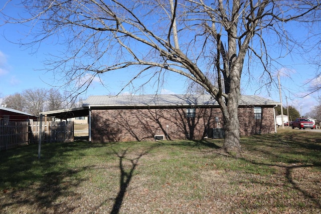 back of house with a lawn and a carport