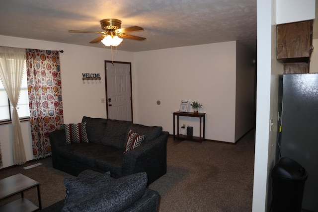 carpeted living room with ceiling fan and a textured ceiling