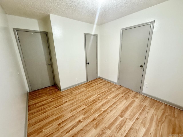 unfurnished bedroom with light hardwood / wood-style floors and a textured ceiling