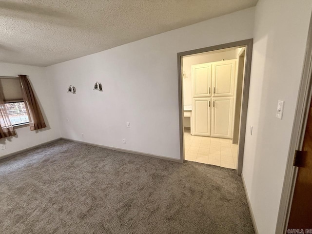 carpeted spare room featuring a textured ceiling