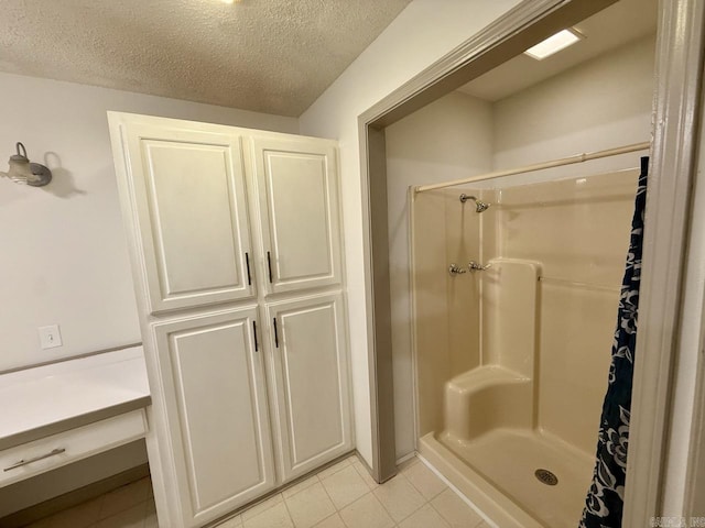 bathroom with tile patterned floors, a textured ceiling, and a shower with shower curtain