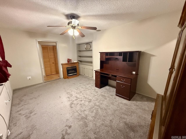 carpeted home office with ceiling fan and a textured ceiling