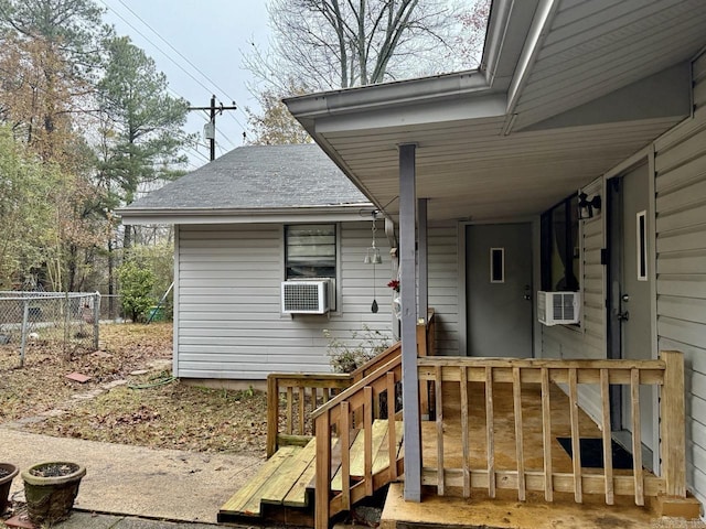 view of exterior entry featuring a deck and cooling unit