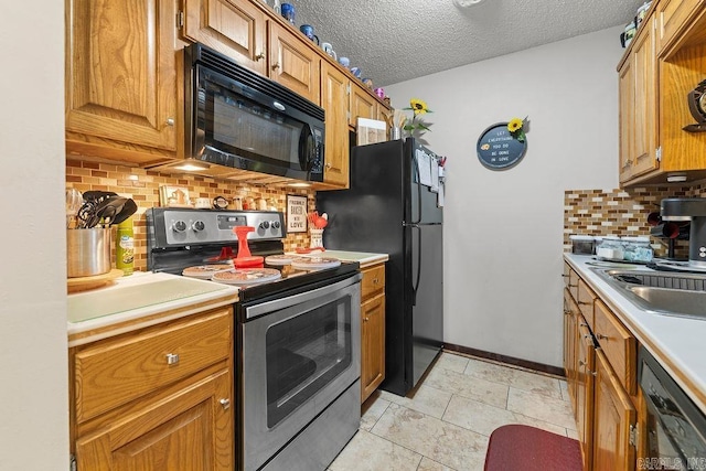 kitchen featuring sink, a textured ceiling, tasteful backsplash, and black appliances