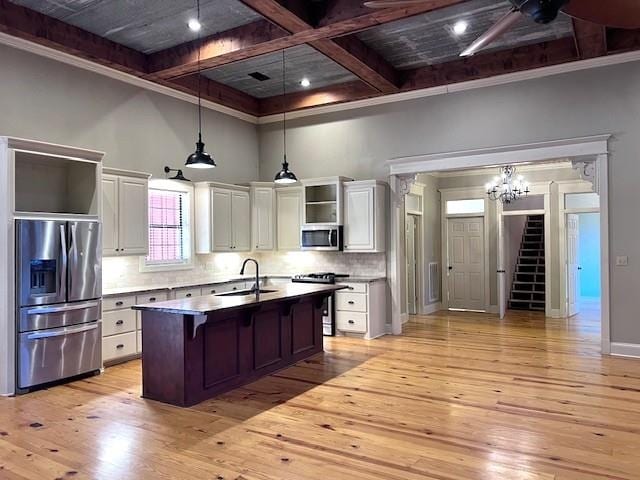 kitchen featuring white cabinets, stainless steel appliances, light hardwood / wood-style flooring, and an island with sink