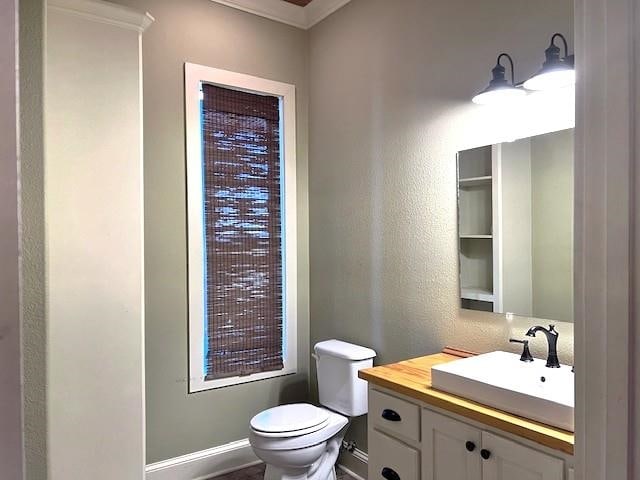 bathroom featuring crown molding, vanity, and toilet