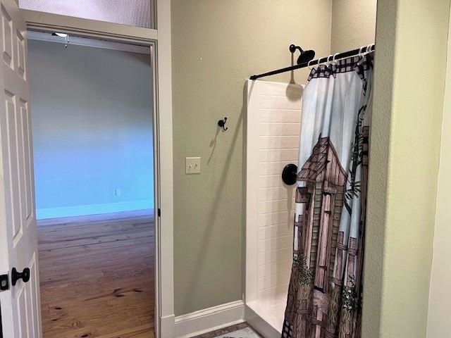 bathroom with wood-type flooring and walk in shower