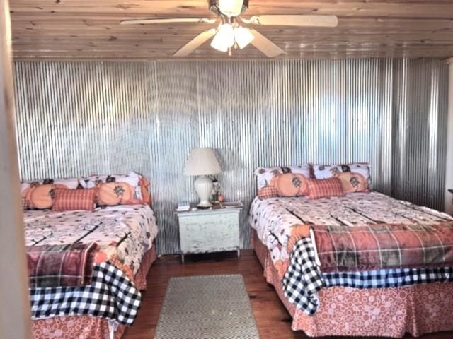 bedroom with ceiling fan, dark wood-type flooring, and wooden ceiling