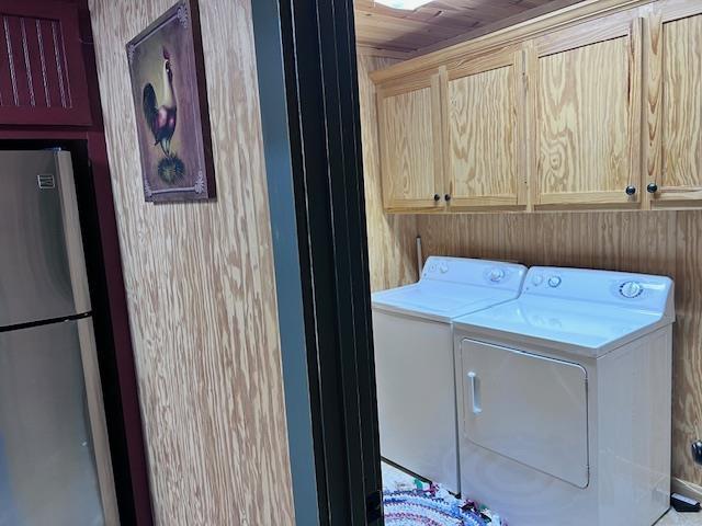 laundry room with separate washer and dryer, wooden ceiling, wooden walls, and cabinets