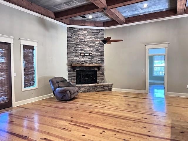 living room with ceiling fan, a fireplace, beamed ceiling, and wood-type flooring