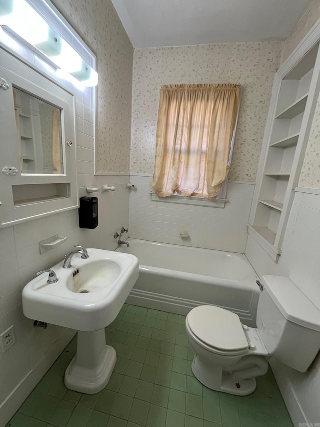 bathroom featuring tile patterned flooring, toilet, tile walls, and a tub