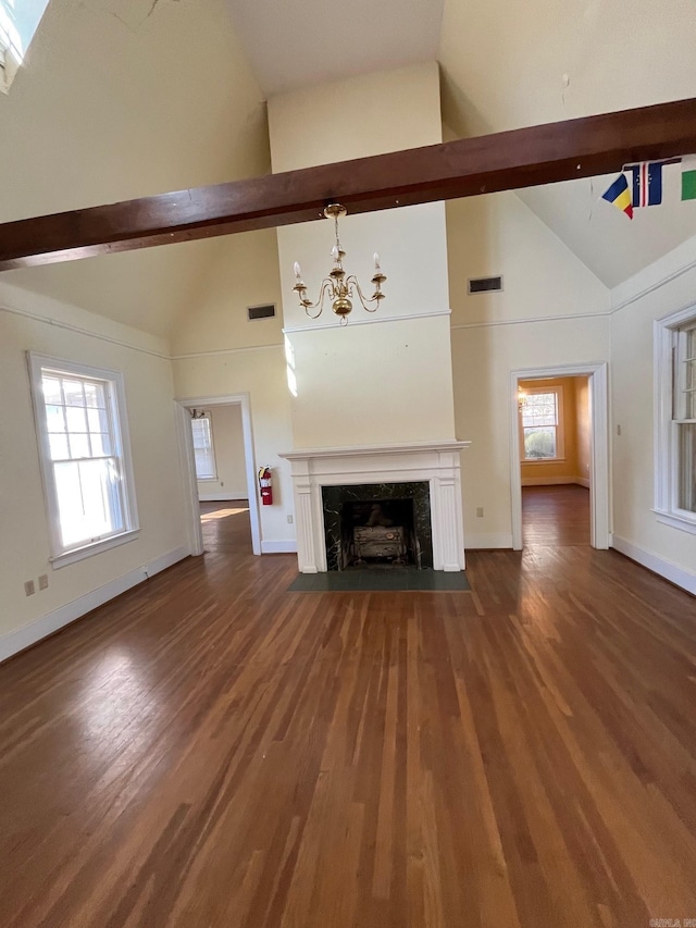 unfurnished living room featuring beamed ceiling, dark hardwood / wood-style floors, a high end fireplace, and high vaulted ceiling