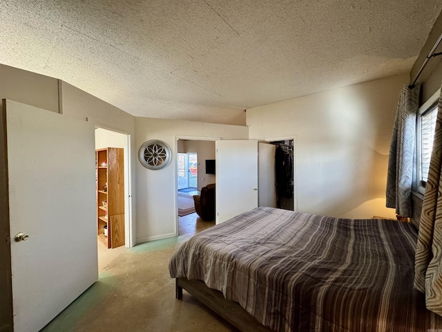 bedroom featuring ensuite bathroom, a textured ceiling, and multiple windows