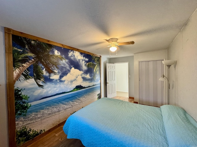 bedroom featuring ceiling fan, wood-type flooring, and a textured ceiling