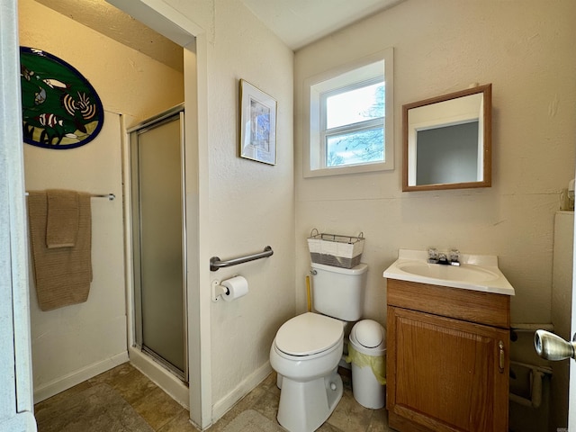 bathroom featuring vanity, toilet, and a shower with door