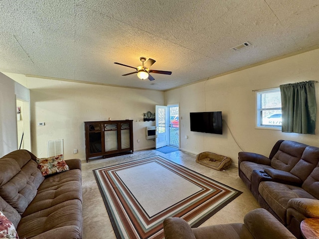 carpeted living room featuring ceiling fan, crown molding, and a textured ceiling